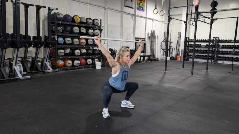 athlete doing an overhead squat with e PVC pipe