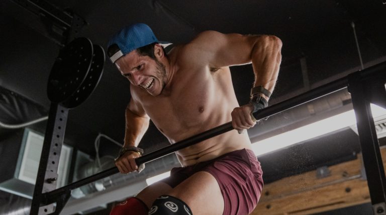 athlete doing a bar muscle up